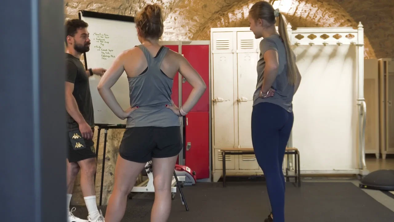 Le coach échange avec deux participantes au Small Group dans le studio de Bordeaux Nansouty